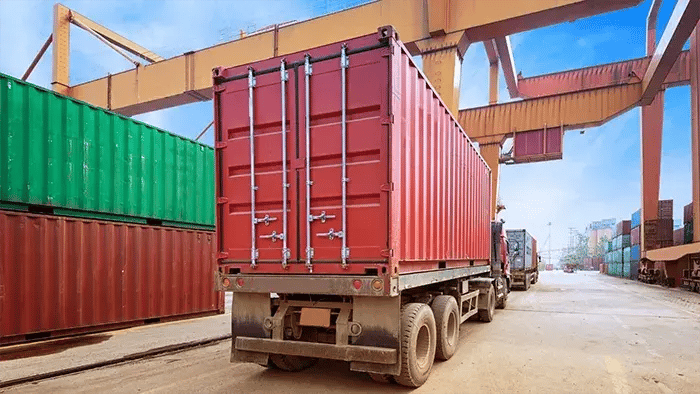 Cargo container for overseas shipping in shipyard with heavy machine . Logistics supply chain management and international goods export concept .